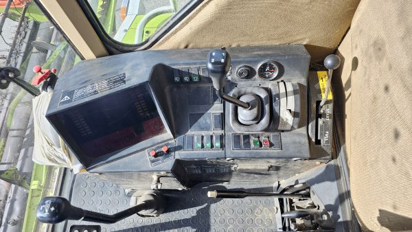 Close-up view of the Claas Dominator 98S control panel, showing gears, buttons, and display controls.