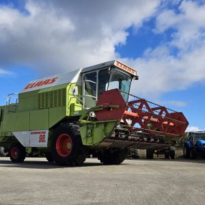 Front-right side view of the Claas Dominator 98S combine harvester, showcasing its large tires and advanced design.