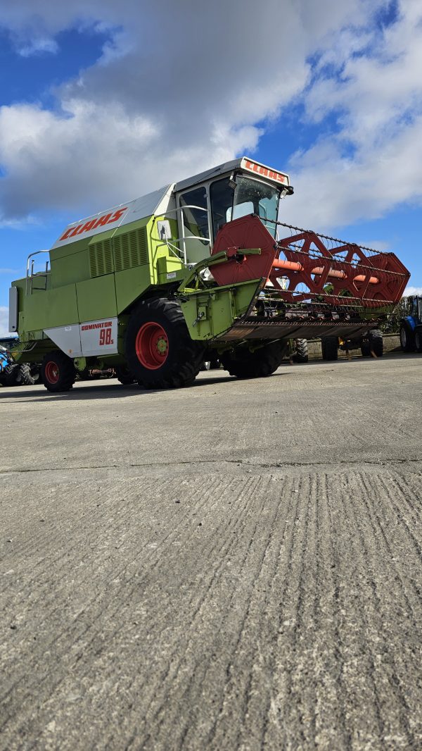 Front right side view of the Claas Dominator 98S combine harvester, highlighting its grain tank, wheels, and engine area.