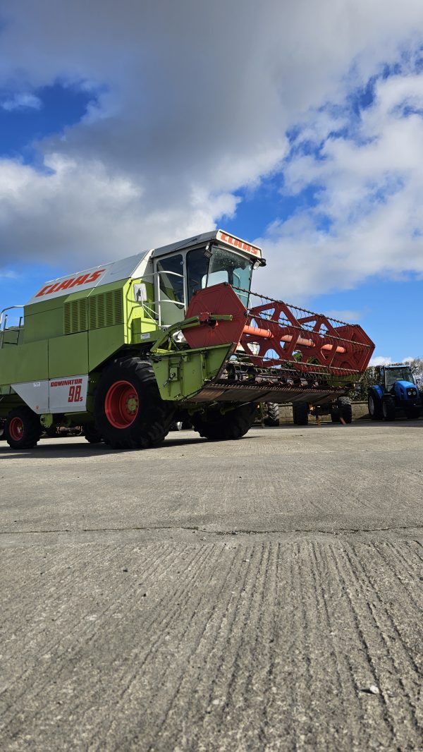 Front right side view of the Claas Dominator 98S combine harvester, highlighting its grain tank, wheels, and engine area.