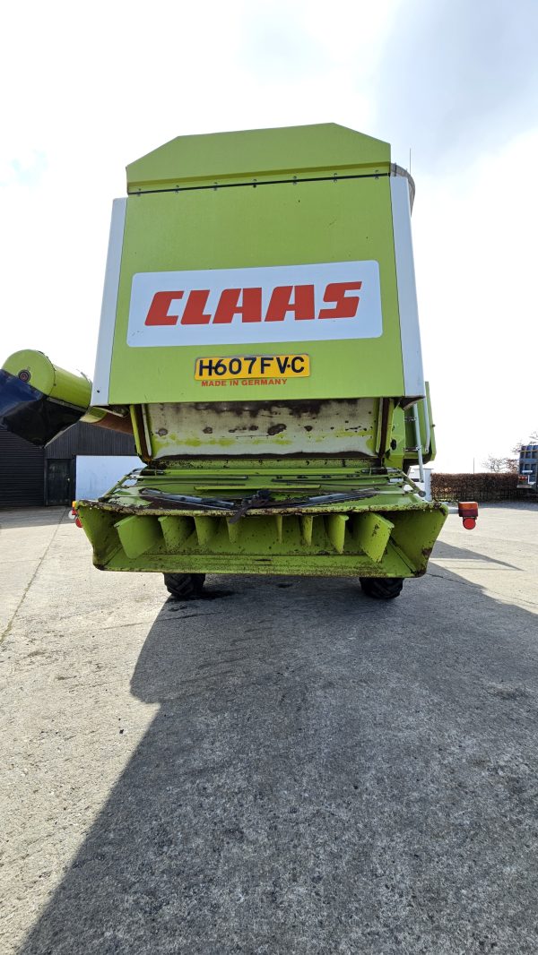 Back view of the Claas Dominator 98S combine harvester, showing the rear end with the exhaust system, unloading chute, and rear wheels.