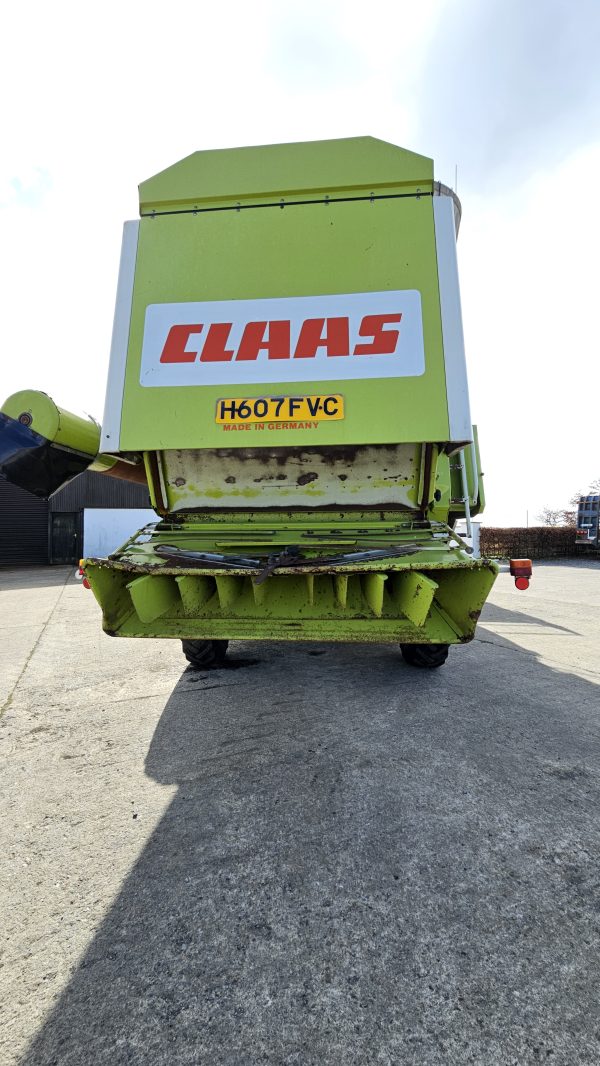 Back view of the Claas Dominator 98S combine harvester, showing the rear end with the exhaust system, unloading chute, and rear wheels.