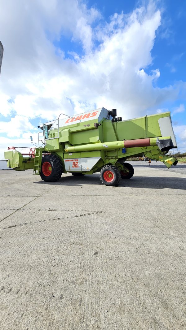 Back left side view of the Claas Dominator 98S combine harvester, showing the rear wheels, exhaust, and attachment points.