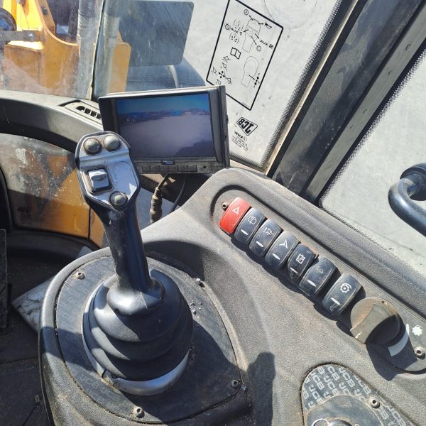 Interior of the New Holland T6070 showing the gear shift, buttons, and digital display, highlighting the advanced control features for the operator.