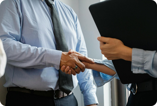 Two business professionals hanging hands in a professional setting.