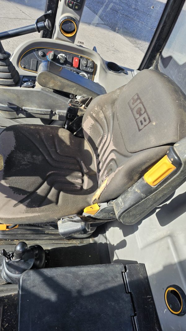 Inside view of the JCB TM 320S cabin showing the seat, control panel, and dashboard.