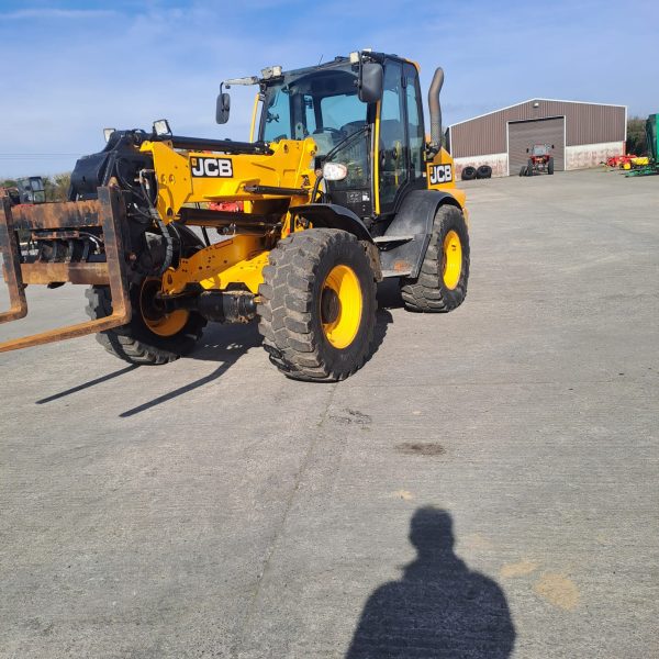 Front left side view of the JCB TM 320S, showcasing its wheel, front grille, and design features.