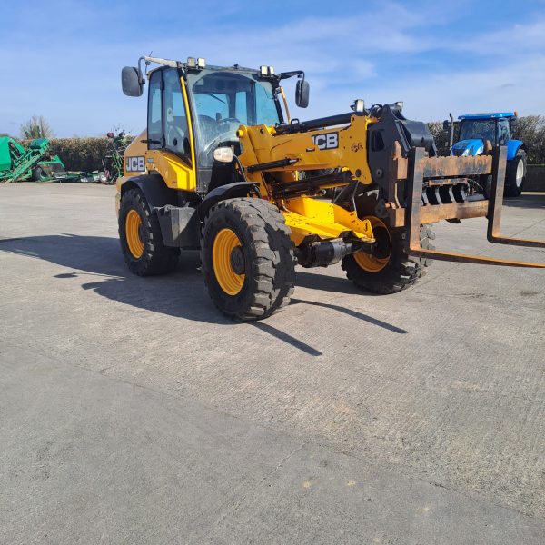 Front right side view of the JCB TM 320S, highlighting its front profile, wheel, and design for heavy-duty tasks.