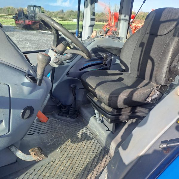 Landini Vision 105 tractor interior showing black seat, steering wheel, and gearshift from the front side view.