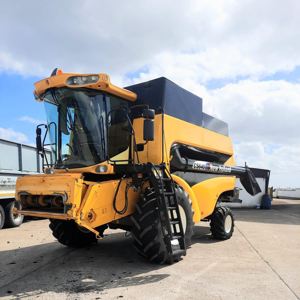 Front diagonal view of the New Holland Combine CS 640, showcasing its advanced design and visible stairs for easy access to the cabin.