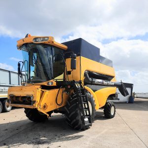 Front diagonal view of the New Holland Combine CS 640, showcasing its advanced design and visible stairs for easy access to the cabin.