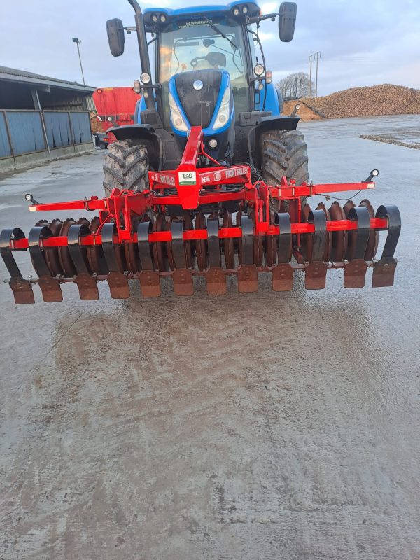 Front view of the Front Press HI VA attached to a tractor, showcasing its heavy-duty construction and precision for field compaction.