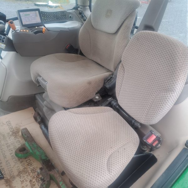 Inside the tractor cabin with grey seats, showcasing the ergonomic design and seating for comfortable operation.