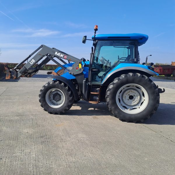 Side view of a blue U8 MX tractor, showcasing its design and features in an agricultural setting.