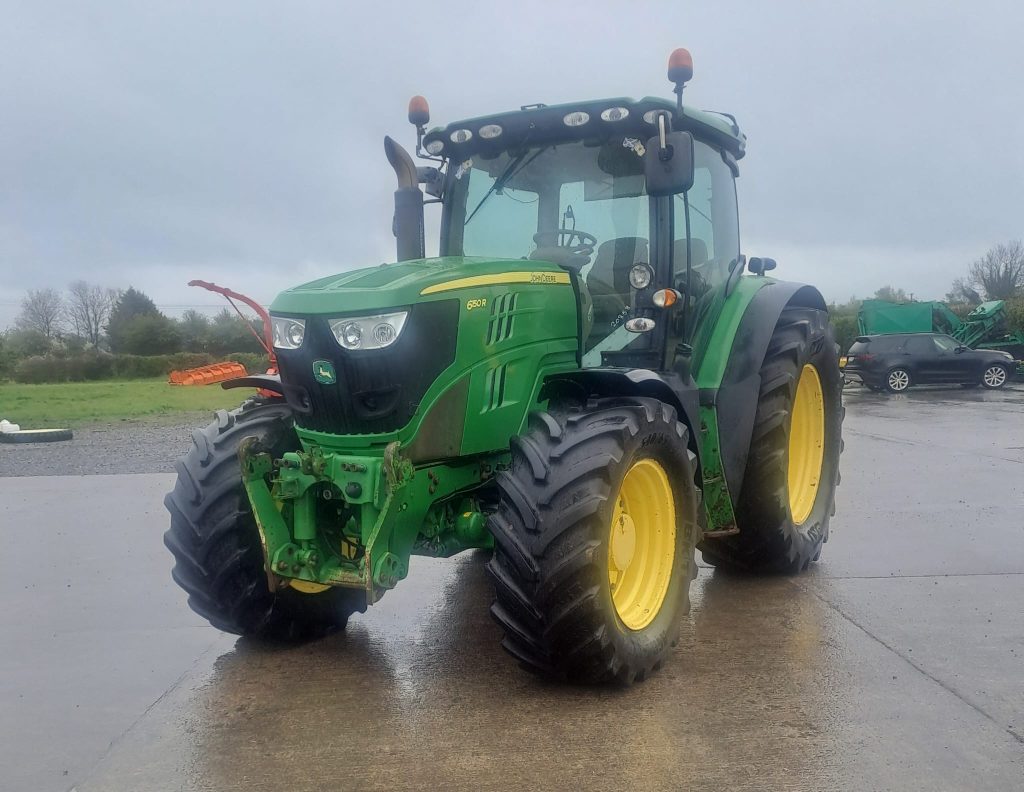 Front view of a John Deere tractor pointing southwest, showcasing its powerful design and agricultural machinery features.