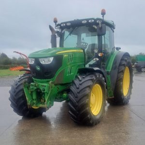 Front view of a John Deere tractor pointing southwest, showcasing its powerful design and agricultural machinery features.